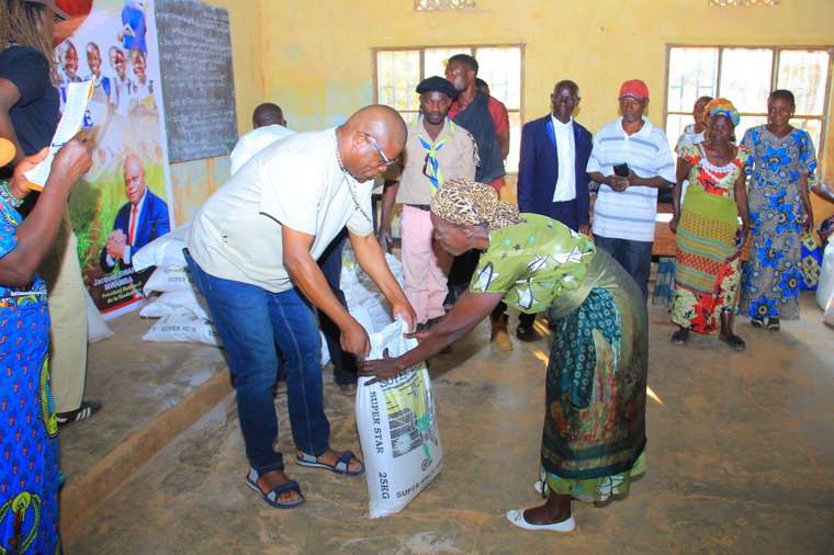Le président de la fondation remet un sac de vivres à une bénéficiaire